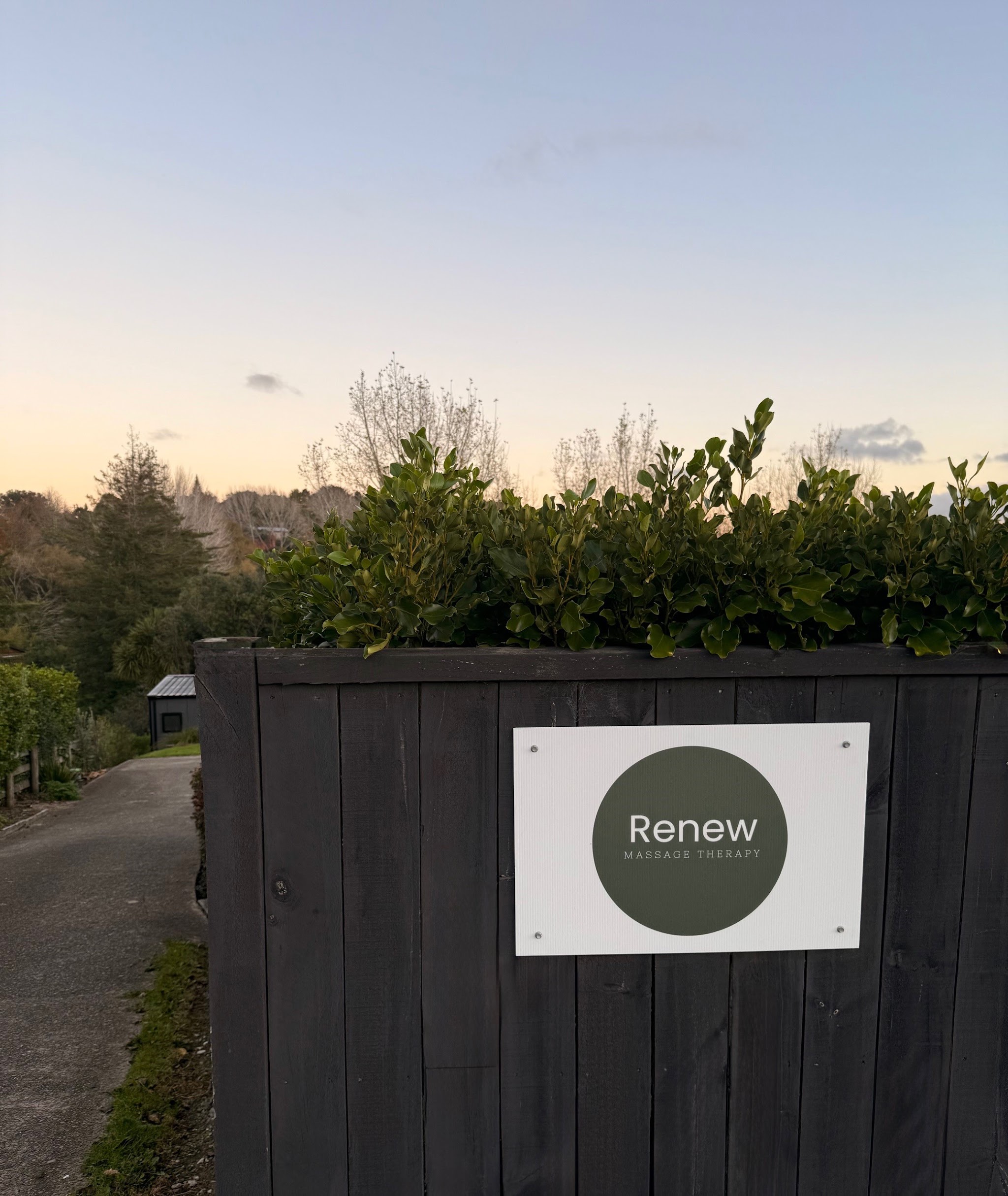 The Renew Massage Therapy sign at the studio entrance at dusk